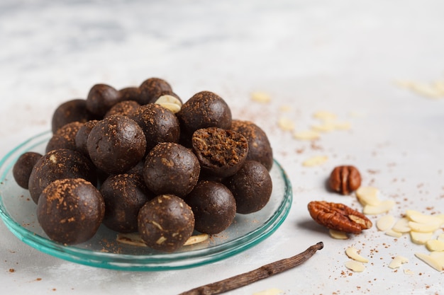 Ванильно-шоколадные сырые веганские сладкие шарики с орехами, финиками и какао. Концепция здорового веганского питания. Серый фон