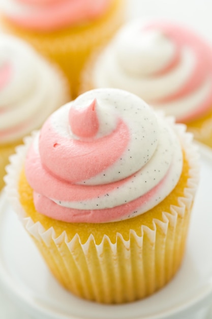 Vanilla cupcakes topped with strawberry cream.