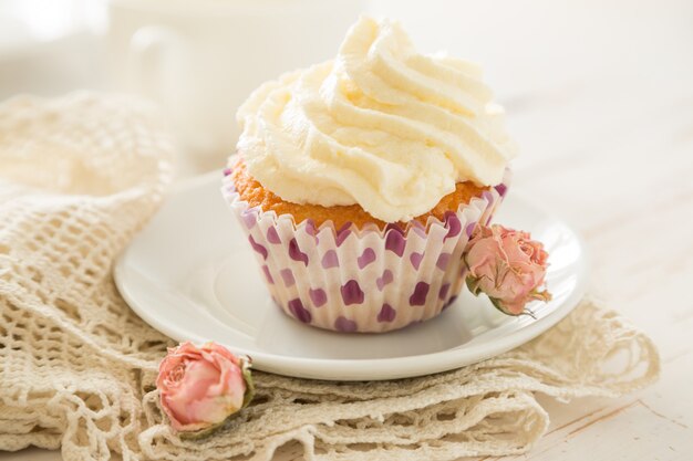 Vanilla cupcakes on white wood 