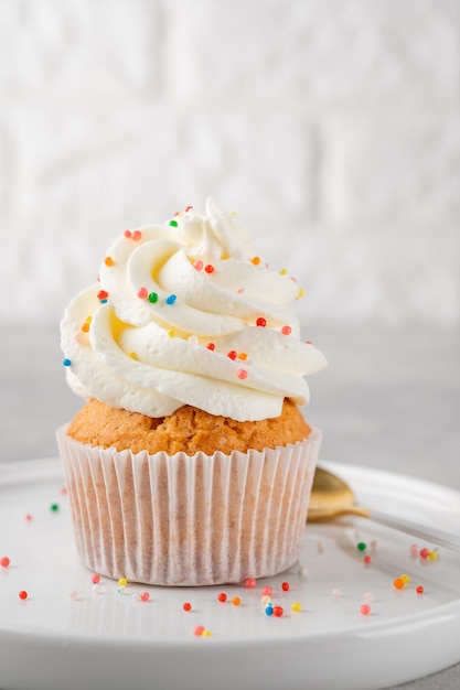 Cupcakes alla vaniglia con crema di formaggio e zucchero candito dessert per lo spazio della copia del fuoco selettivo di compleanno