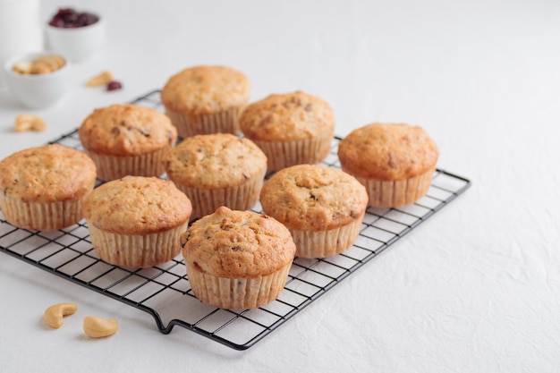 Vanilla fresh baked muffins on a white table with nuts and berries