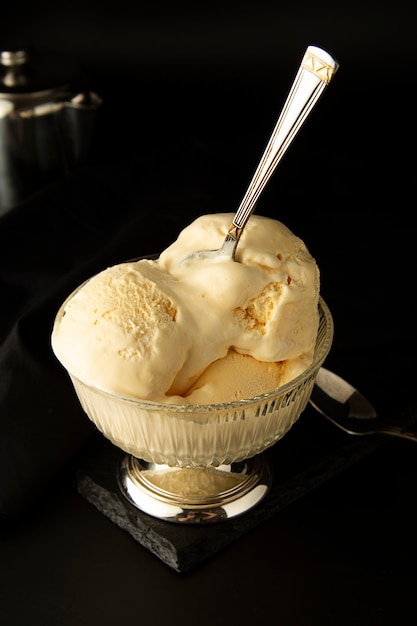 Vanilla Ice Cream scoops in glass elengant cup. Isoalted over black background with copy space