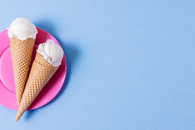 Palline di gelato alla vaniglia con coni e copia spazio