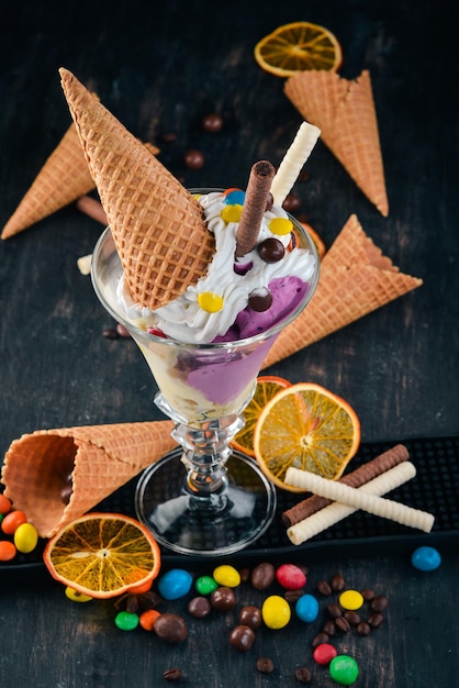 Vanilla ice cream with colored candies On a black wooden background Copy space