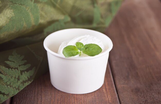 Vanilla ice cream with mint leaf on the wooden table. Copy space.