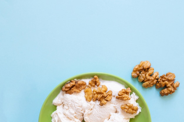 Vanilla ice cream with walnut on green plate. copyspace