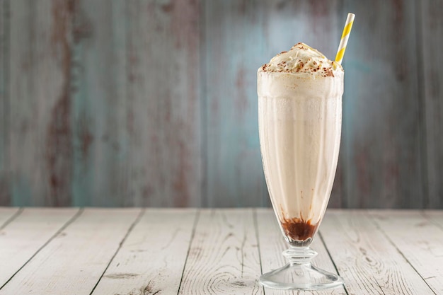 Milkeshake alla vaniglia con panna montata e salsa al cioccolato.