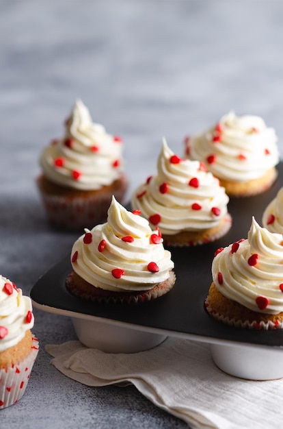 Vanilla muffins on plates and a white cloth on a grey background