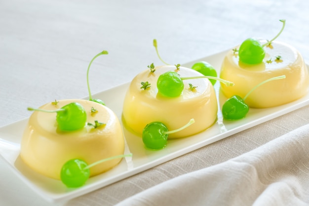 Vanilla puddings decorated with cocktail cherries