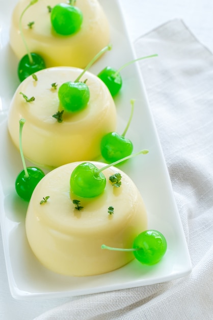 Vanilla puddings decorated with cocktail cherries