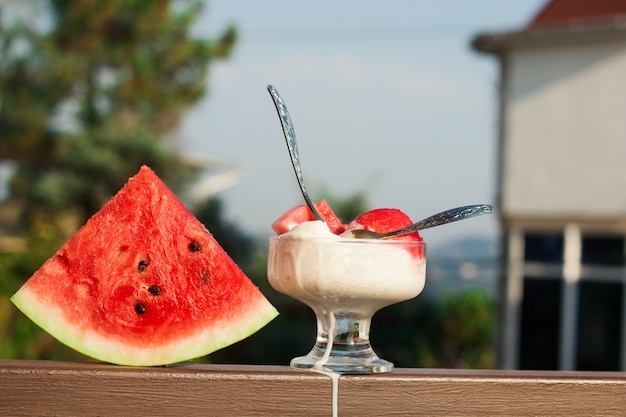 Vanille-ijs geserveerd met watermeloenschijfjes, koud zomerdessert op het terras