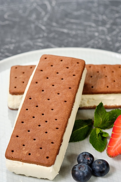 Vanille-ijs met koekjes op een witte plaat met bessen