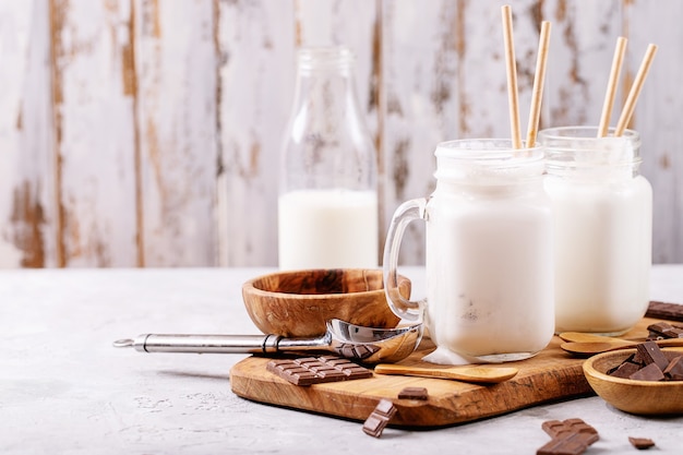 Foto vanille milkshake geserveerd met chocolade op witte textuur achtergrond