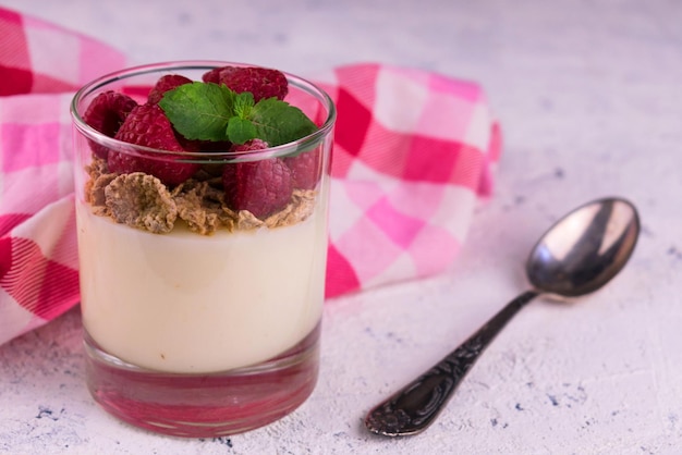 Vanillepudding met frambozen in een glas op een witte achtergrond Close-up