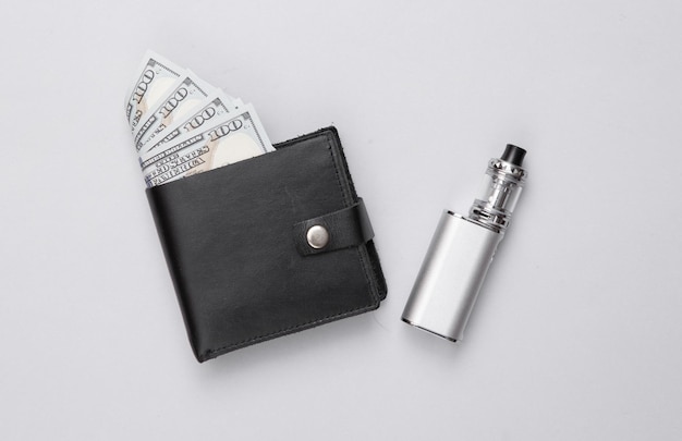 Vaping device and wallet with money on a gray background\
smoking costs