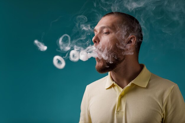 L'uomo che svapa lancia un anello di fumo