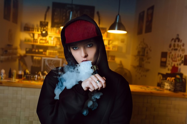 Vaping meisje jonge hipster vrouw vape ecig bij de vapeshop hiphop stijl close-up