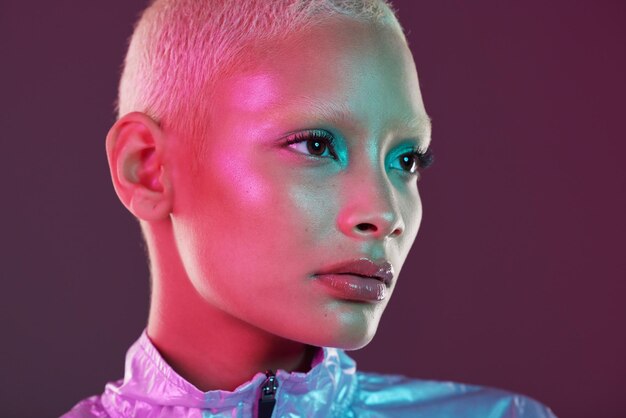 Vaporwave profile black woman and cyberpunk cosmetics with model thinking in a studio isolated glow makeup and futuristic cyber fashion of a young person with chrome clothing and scifi design