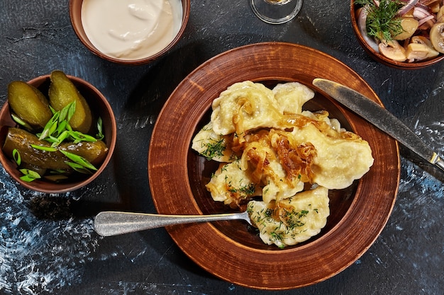 ポテトフィリングと揚げ玉ねぎのバレニキとサワークリームのピクルス添え