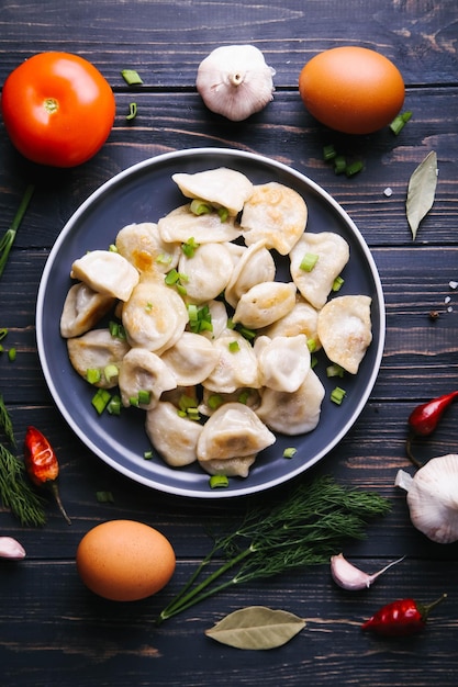 Vareniki with potatoes and onions on a dark plate