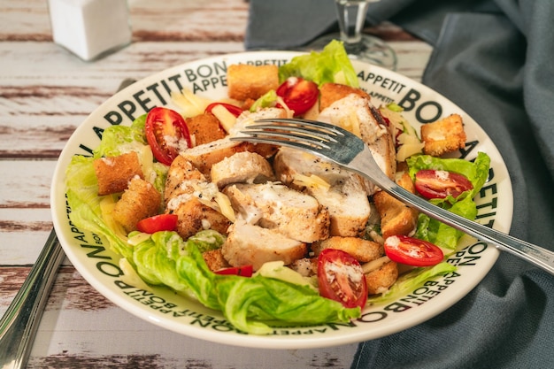 Variazione di caesar salad con fettine sottili di pollo alle ciliegie e salsa aioli gourmet in una ciotola Foto Premium