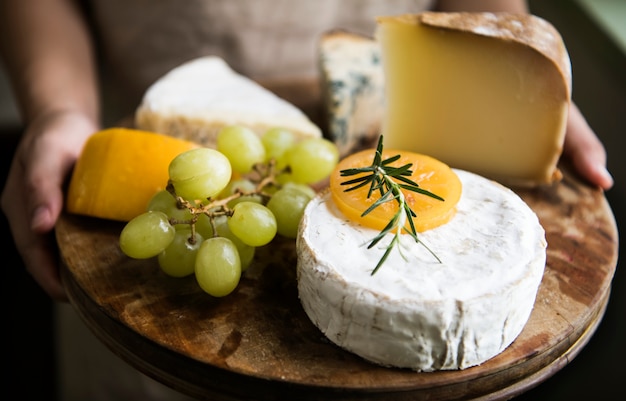 Variation of cheese and green grapes on a wooden platter food photography recipe idea