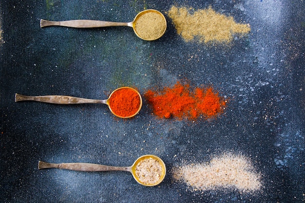 Variation of spices on the vintage silver spoons, all spices on the table, colorful food  