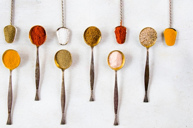 Photo variation of spices on the vintage silver spoons, all spices on the table, colorful food