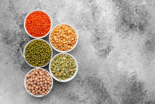 Variations of porridges and bean in white saucers on a gray concrete background