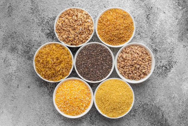 Variations of porridges and bean in white saucers on a gray concrete background