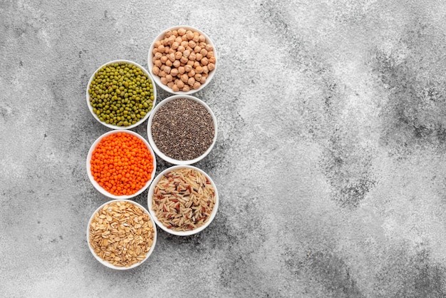 Variations of porridges and bean in white saucers on a gray concrete background