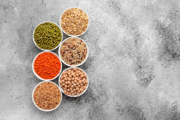 Variations of porridges and bean in white saucers on a gray concrete background