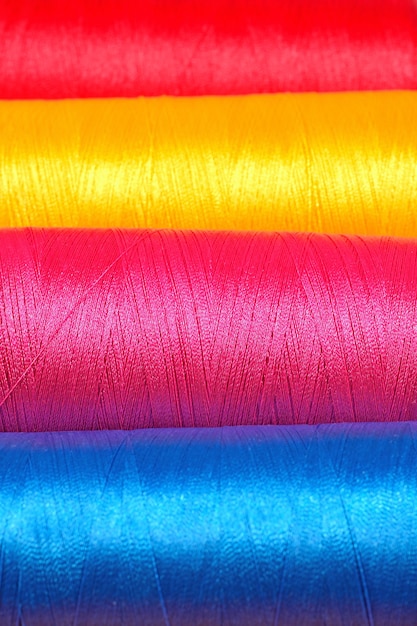 Varicolored spools thread macro background