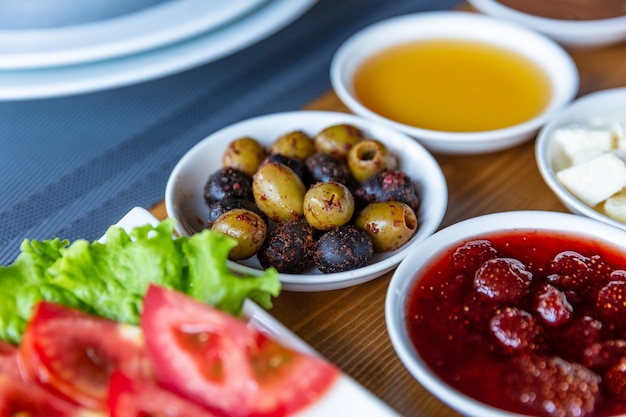 Varied breakfast, set of scrambled eggs with tomatoes and classic scrambled eggs, different types of snacks