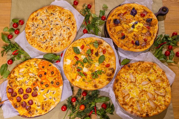 Varied pizzas with sauce. On a wooden table.