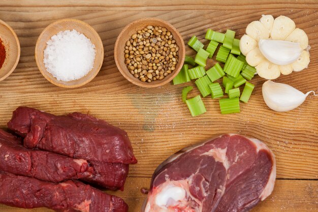 Varieties of meat with spices on wooden board