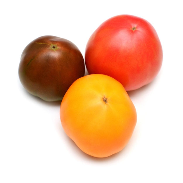 Varieties of tomatoes isolated on white background. Assorted tomato is yellow, pink and black prince. Grade. Flat lay, top view