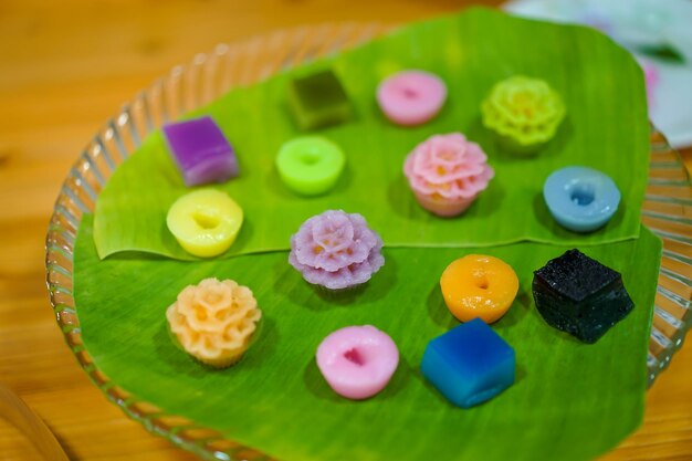 Varieties traditional colorful Thai desserts set NamDokMai steaming flour PiekPoon black custard LeumKluen coconut custard steaming bean KanomChan layer pudding cake