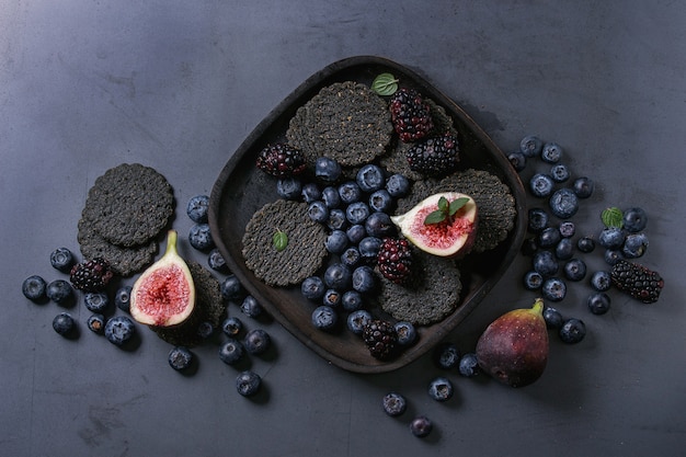 Variety of berries and figs with black crackers