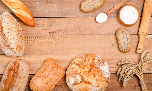 Variety of bread and rolls on wooden table