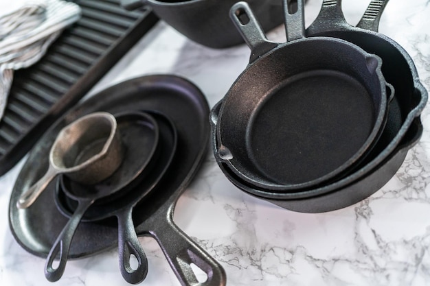 Variety of cast iron frying pans on a marble background.