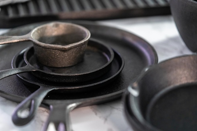 Variety of cast iron frying pans on a marble background.