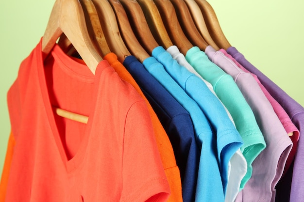 Photo variety of casual shirts on wooden hangerson blue background