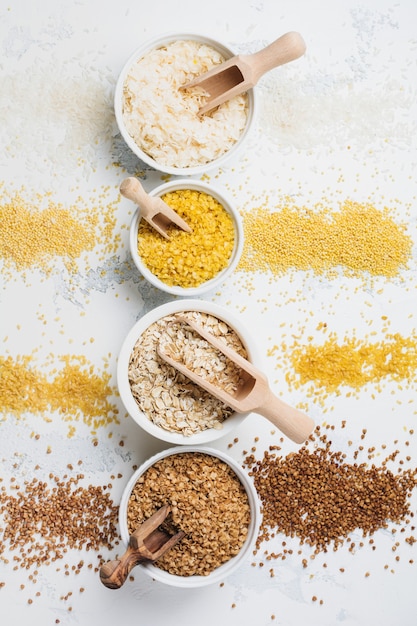 Variety of cereal flakes rice, millet, buckwheat, oatmeal. Superfood in white ceramic bowls