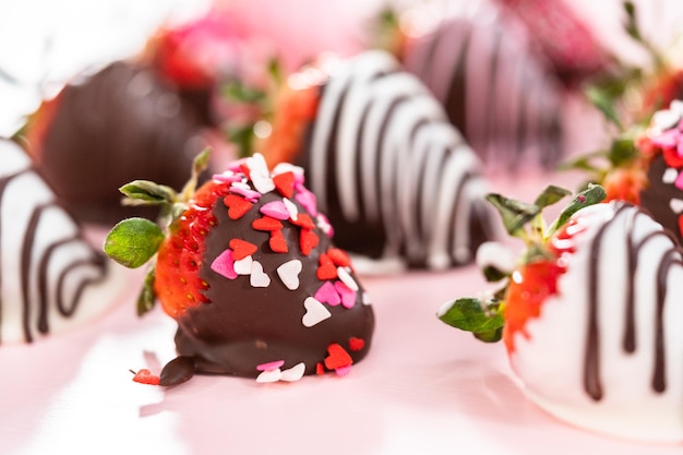 Variety of chocolate dipped strawberries on a pink background