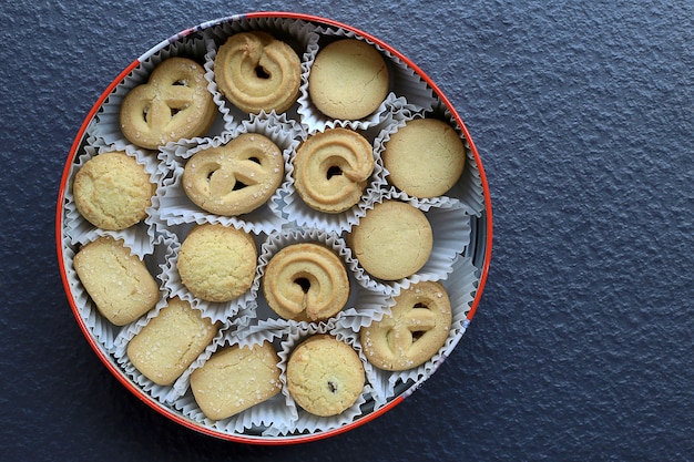 Foto varietà di biscotti al burro di natale su sfondo di pietra nera