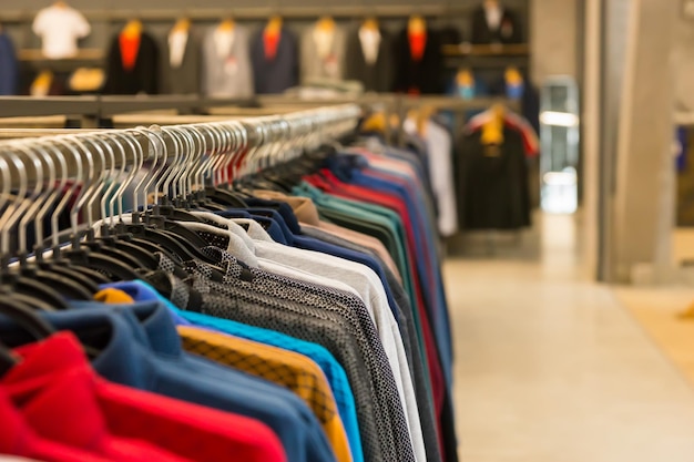 Variety of clothes hanging on rack in boutique, fashion and shopping concept