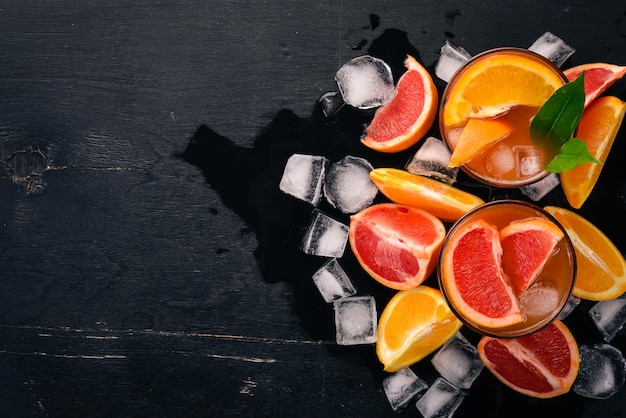 A variety of cocktails of whiskey orange and grapefruit juice Negroni On a wooden black background Top view Copy space