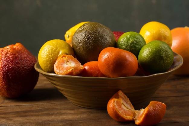 A variety of colorful citrus fruits on the bowl rustic still life