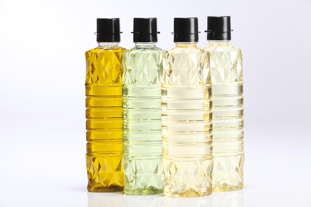 Photo variety of cooking oils in bottles against white background